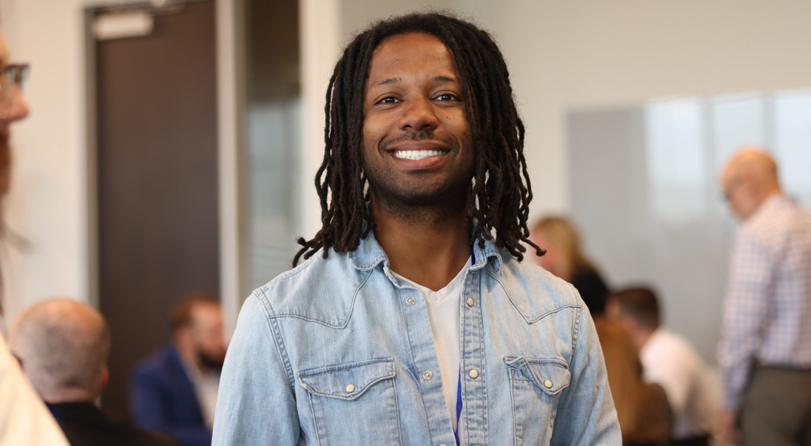 a man smiling at the camera with a health office in the background