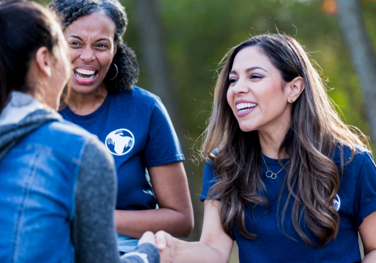 woman smiling as she is shaking hands